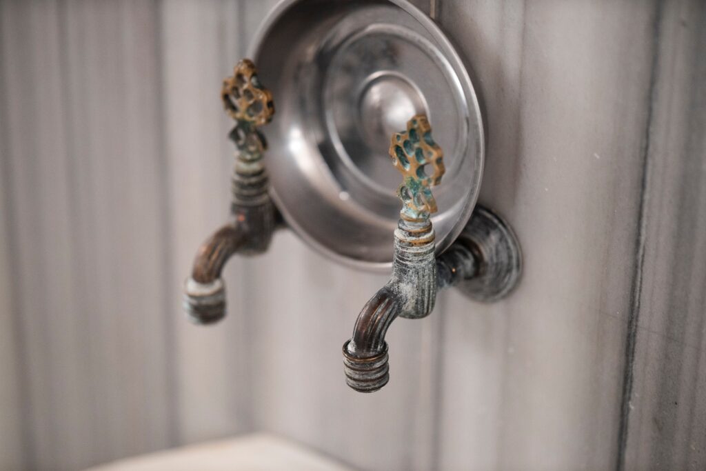 two water taps with a pan resting on them