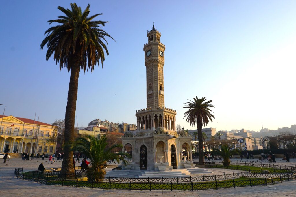 ornate clocktower next to a palm tree