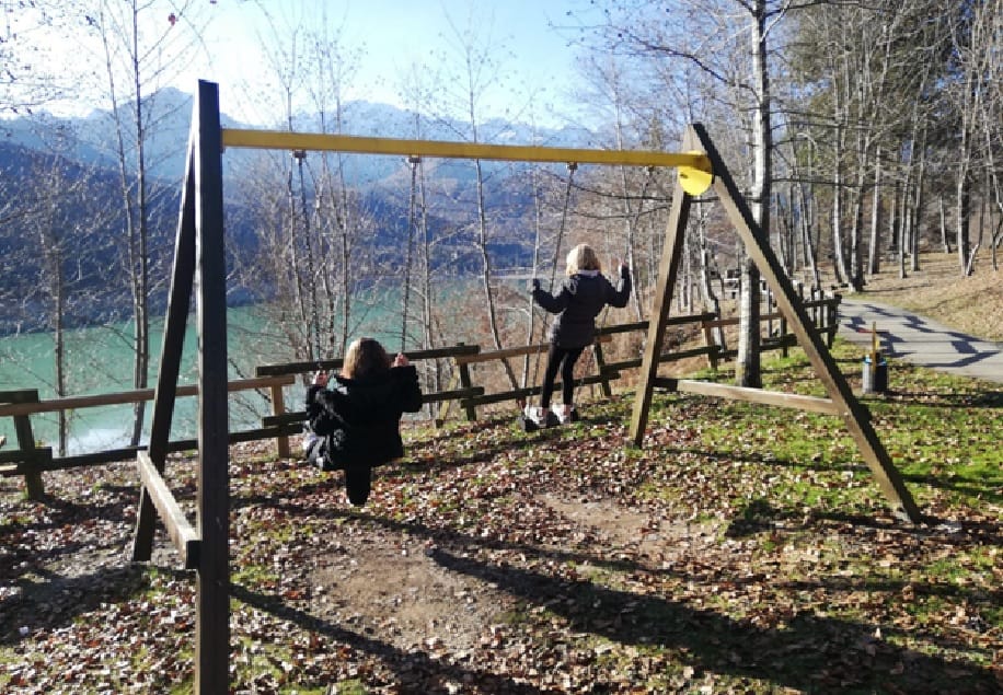 kids swinging in front of Lake Barcis.