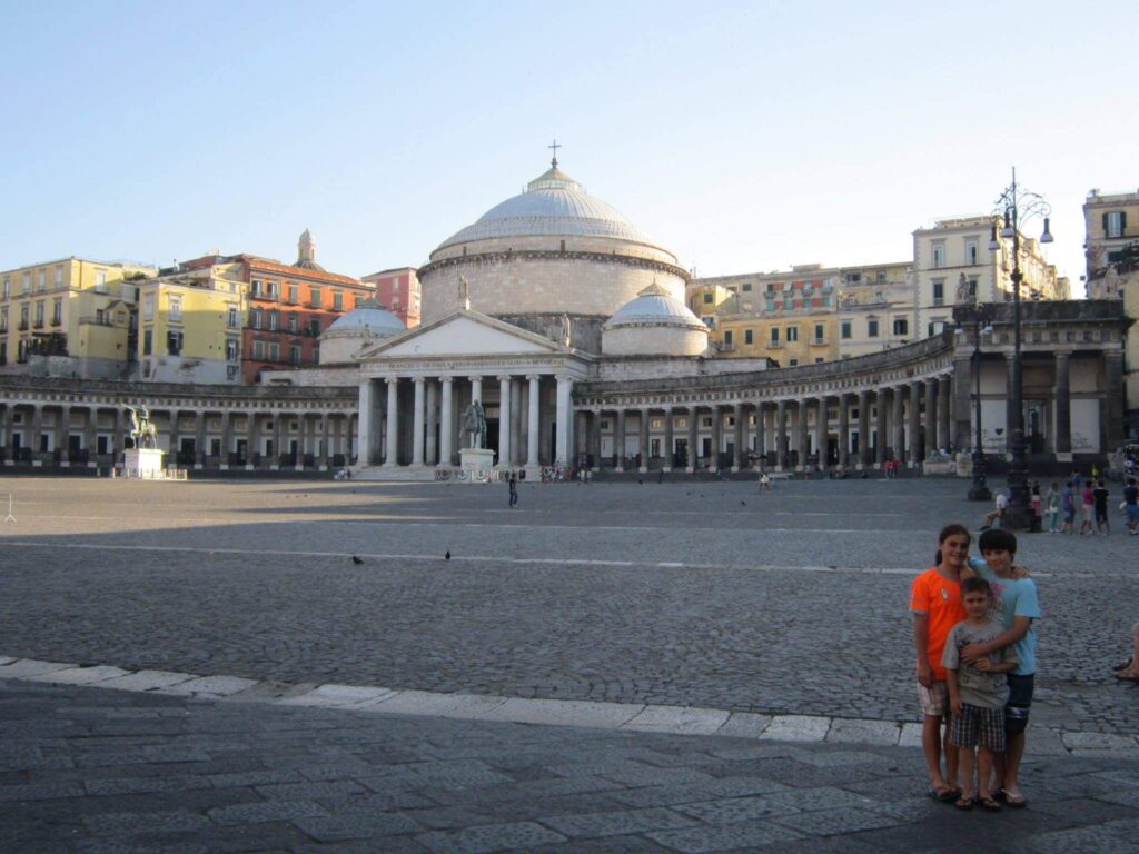 children standing in front of a stone church.