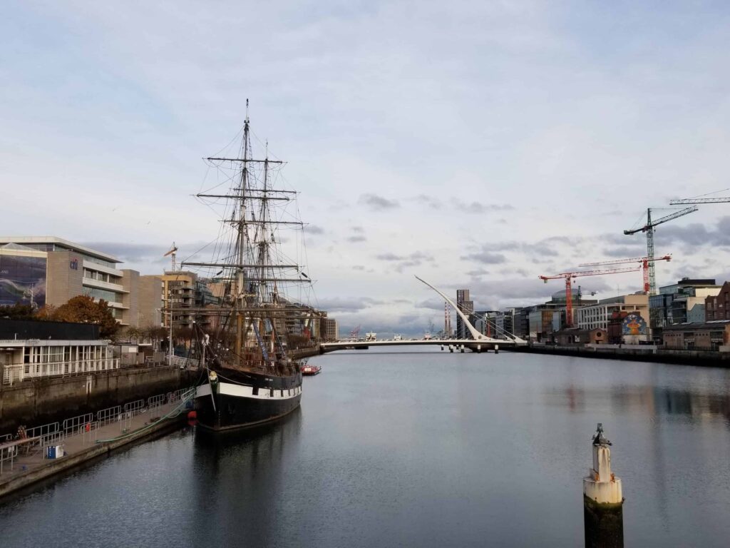 Jeanie Johnston famine ship moored in the river liffey with the harp shaped beckett bridge in the background.