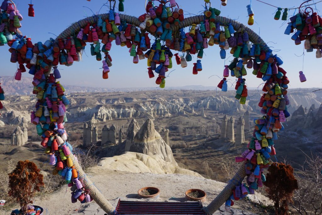 colorful trinkets framing a view of a valley in cappadocia, turkey