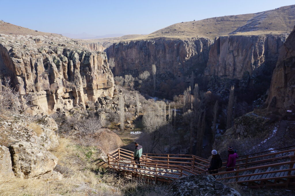 people walking down stairs descending into a valley