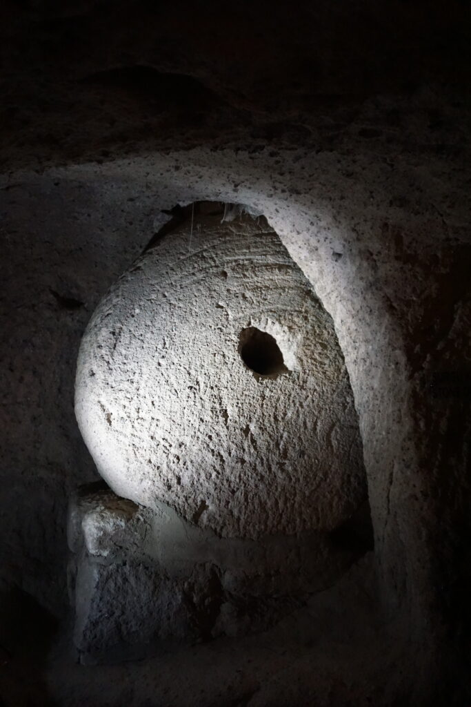 round stone with hole in center used as a door in the underground city in Cappadocia, Turkey