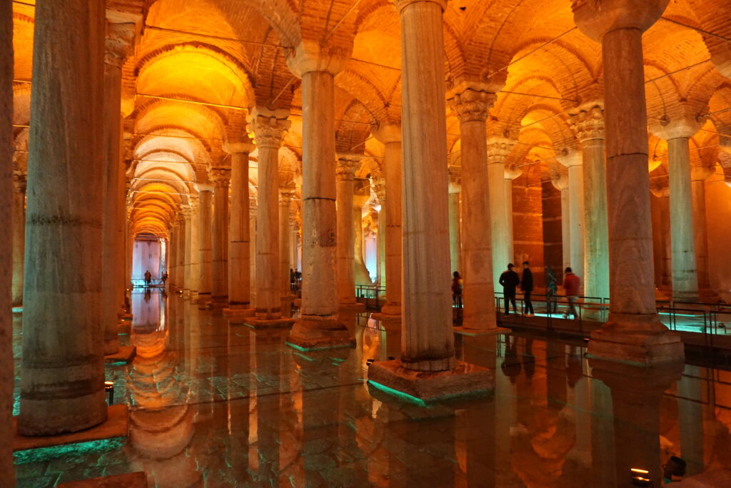 Roman columns of the turkey landmark, the basilica cistern, bathed in a orange-yellow glow of light.