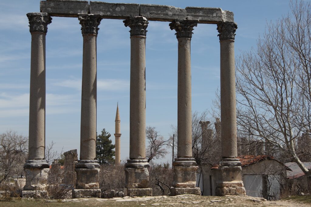 roman column ruins with a  modern minaret in the background.