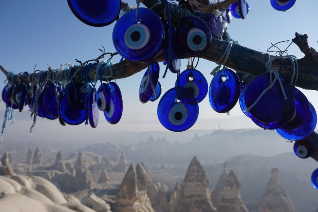 Evil Eye charms hanging on a tree with Cappadocia fairy chimneys in the background