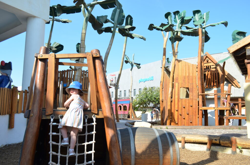 the author's daughter climbs up a ladder at the playmobil fun park in Malta, one of the best places to go in Malta with kids.