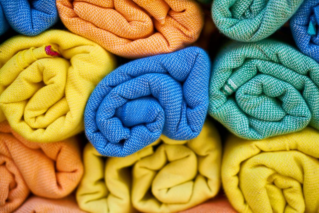 colorful Turkish towels rolled up and stacked on top of each other.