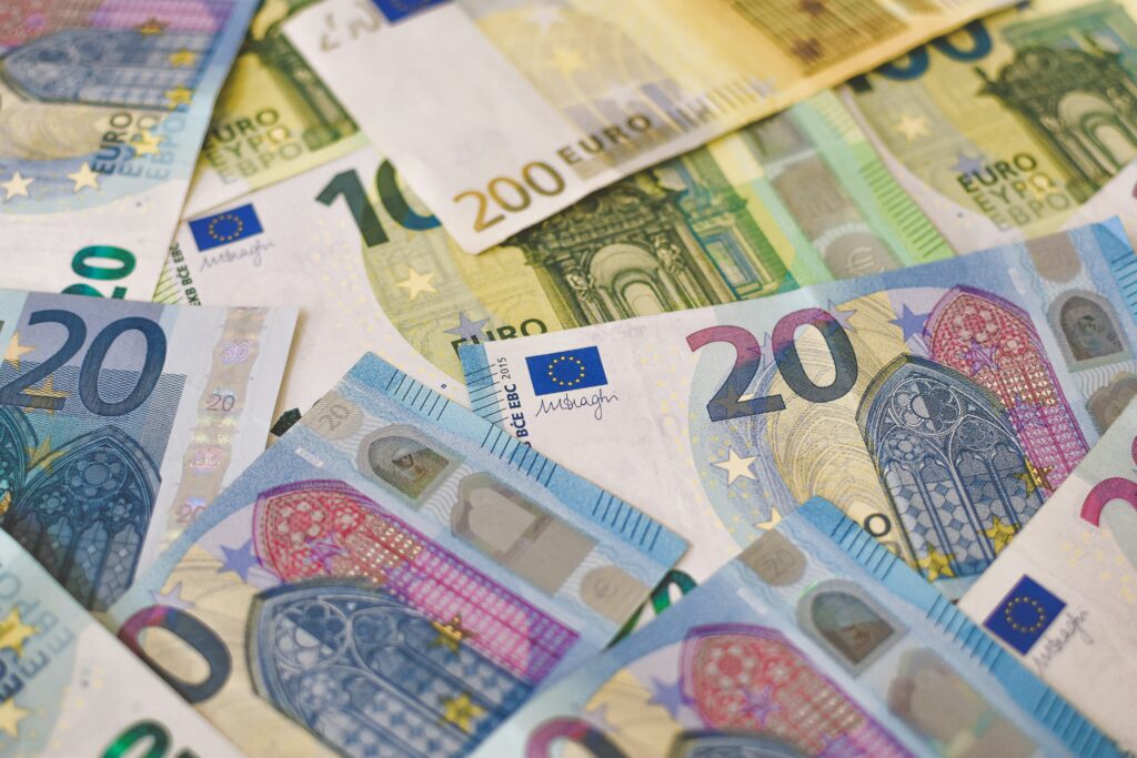 A variety of Euro banknotes spread out, showcasing the currency's different denominations and intricate designs. Budgeting is an important part of planning a weekend getaway.