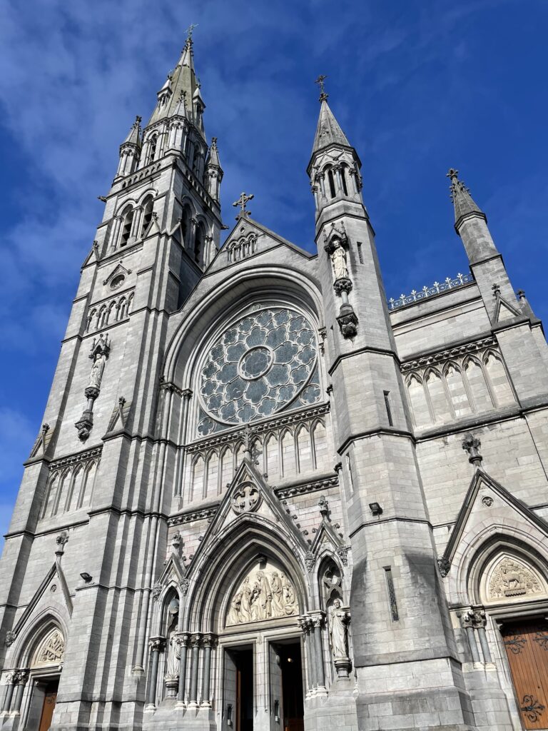 St. Peter's Catholic Church in Drogheda with Gothic architecture, including spires and detailed stone carvings under a clear blue sky.