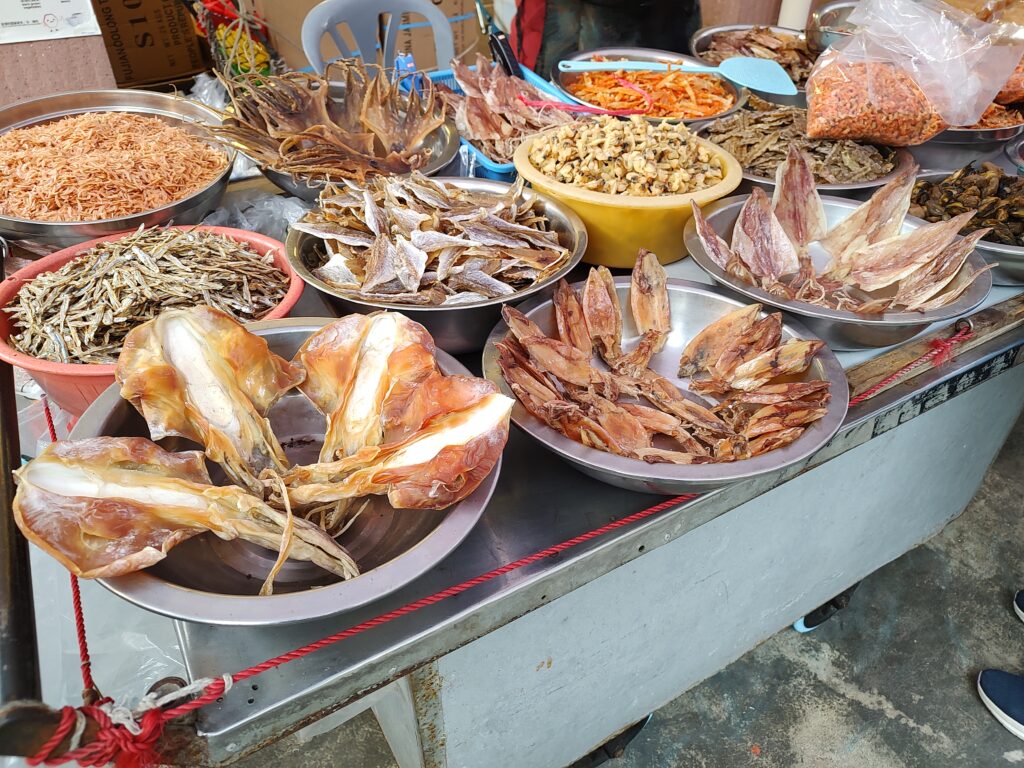 Dried seafood market stall in Tai O. Bowls of dried squid, fish, and shrimp on display.